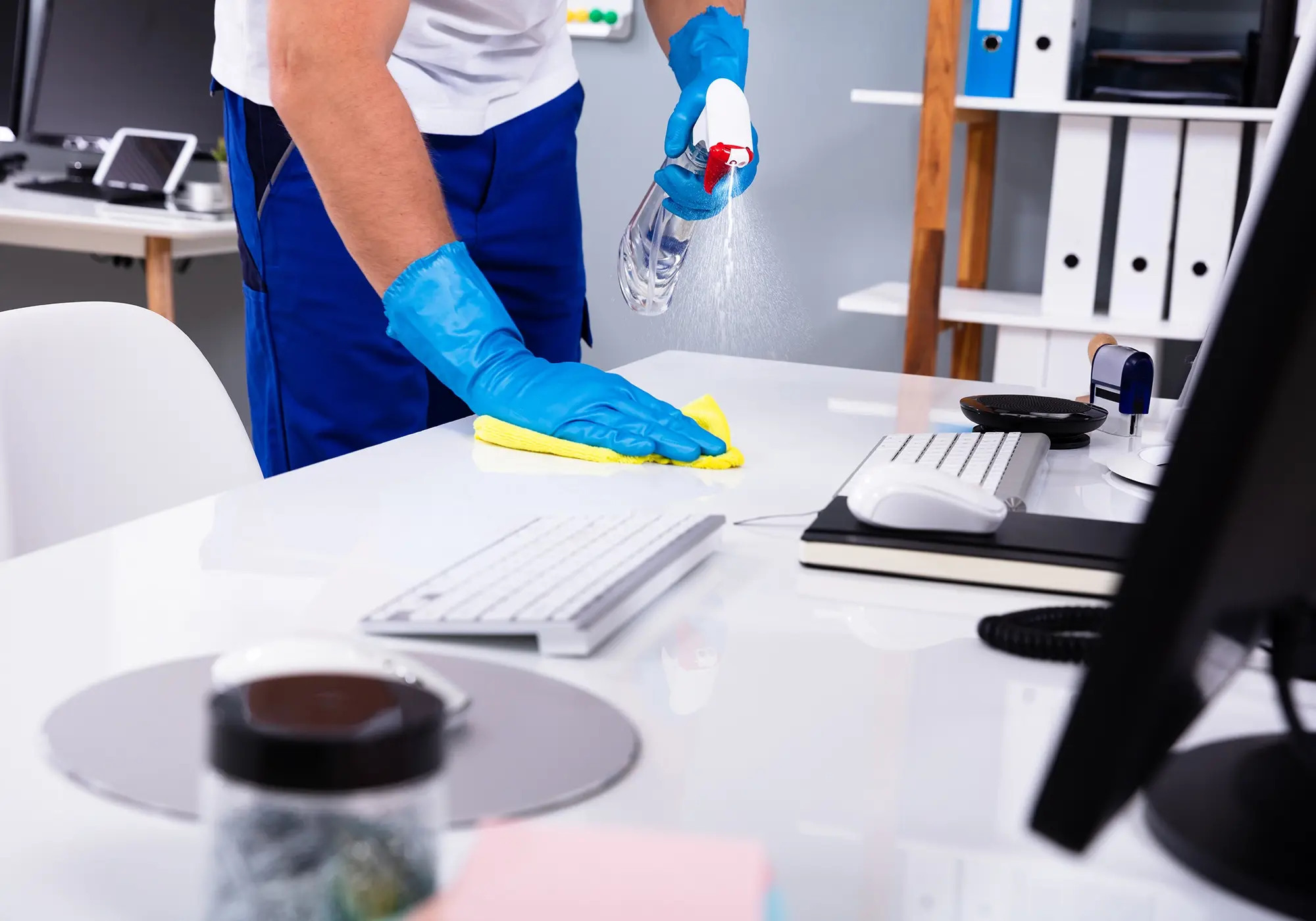 Commercial cleaner disinfecting a workstation surface